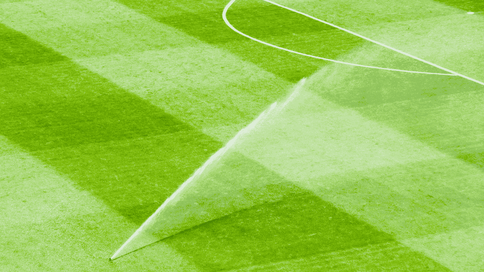 Irrigation system watering well maintained turf grass in landscaped yard